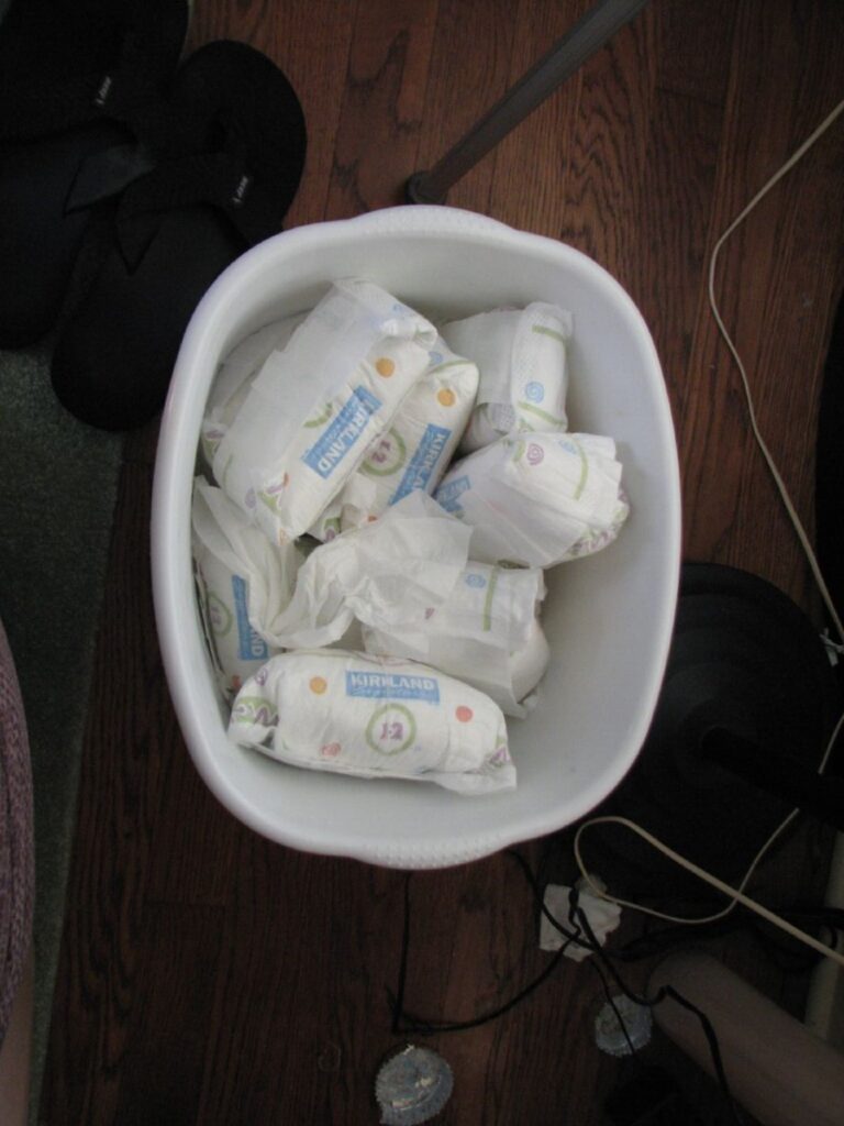 Disposable nappies piled in the rubbish bin.